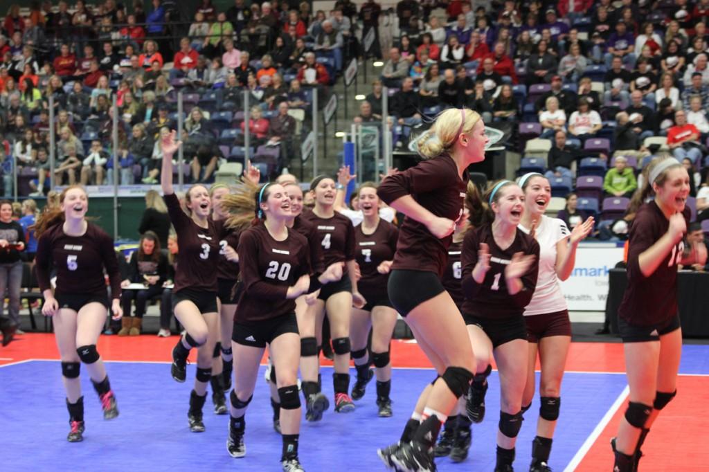 The team celebrates after their victory in four sets over Davenport Assumption. Photo by Ashley Shultz.