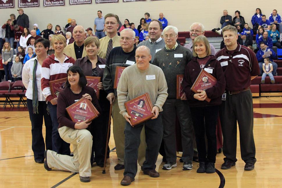 MUSTANG STATE COACHES HALL OF FAME INDUCTEES: Front Row: Carol Woods (Booster Club and former asst. volleyball coach ) and Bill Thomsen.  Row 2: Booster Club president Susie Belding, Stephanie Timm (accepting for her husband Ed Timm), Shirley Ryan, Jim Bellamy, Roger Johanson, Sue Deibner.  Back Row: Bob Landis, Bob Kintzel, Jeff Schwiebert, Bob Meeker, and Athletic Director Joe Wallace. Photo by Taylor Hauser.