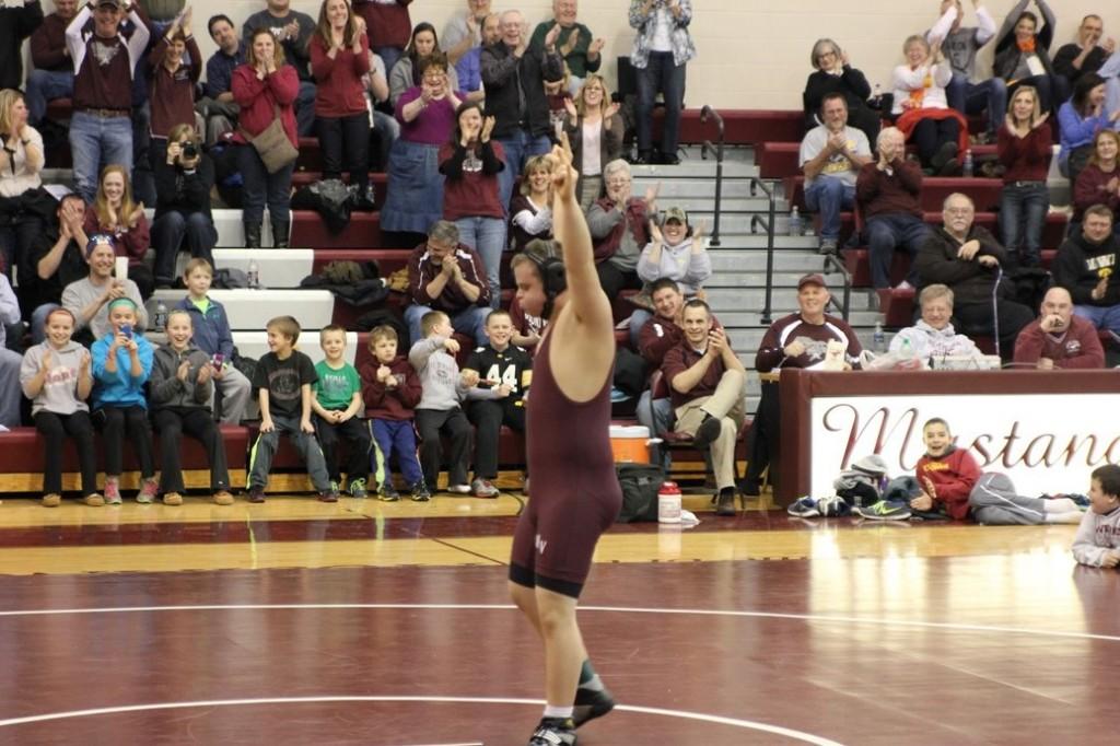 Jacob Steele celebrates his win on Senior Night as the crowd cheers. Photo by Kelsey Shady.