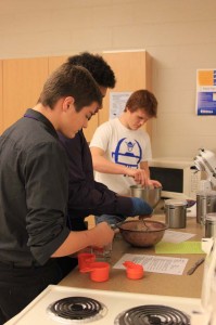 Sophomores Colin Heeren, Marquis Dew and Bryce Cox whip up a recipe in Foods in December. Photo by Laura Deininger.