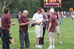 Two of the most dedicated workers, Mike O'Brien and Eric Roudabush, are presented helmets signed by the football team. Photo by Lexi Kelly