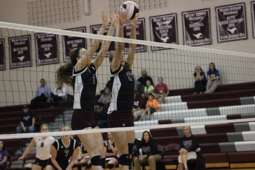 Mount Vernon's  Morgan Melchert (1) and number 17 Kaitlyn Volesky block an attack from Benton Community's middle hitter leading to a point for the Mustangs. Photo by Claire Pettinger.