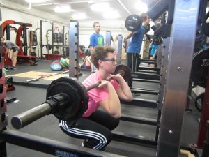 Senior Kate Elsbury lifts weights during earlybird P.E. on Dec. 11. Photo by Jenna Brannaman.