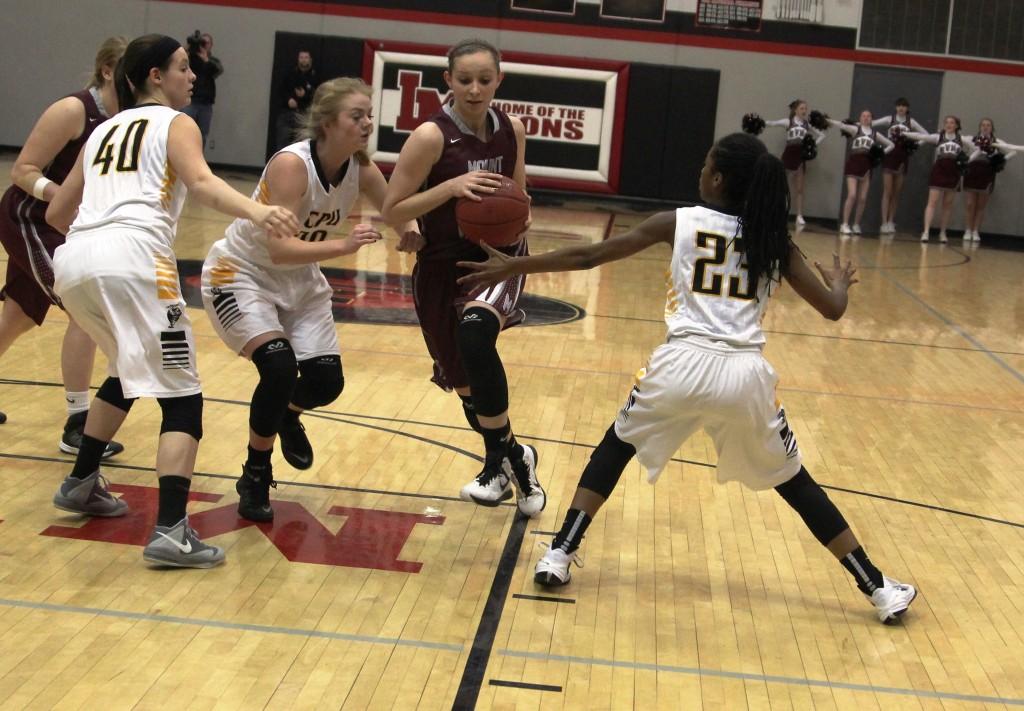 Alli Platte drives between CPU's Payton Hasleiet (20) and LaMia Sisk (23) in the first quarter. The Mustangs were down 11-2 in the first quarter. Alli was the lead scorer for Mount Vernon with 14 points.
