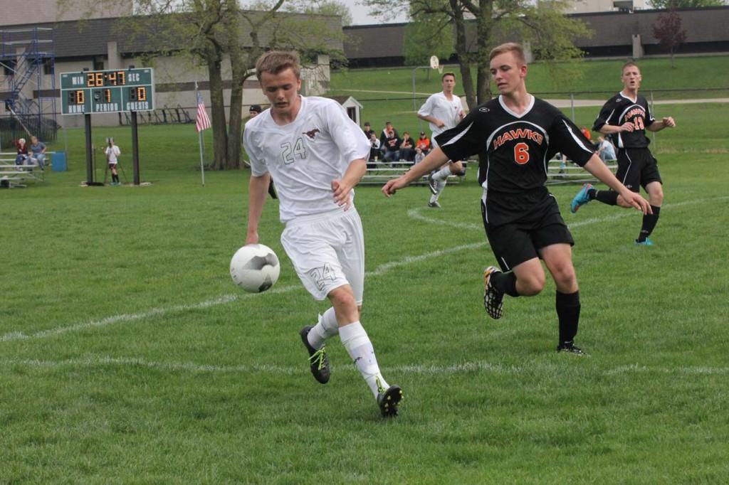 Sophomore Josh Trachta dribbles away from West Delawares Sam Engelken May 4. The Mustangs beat the Hawks 4-1. Photo by Ethan Hill.