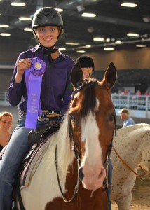 Sitting on her horse Chaco, sophomore Maggie Dale holds up her blue ribbon at the State Fair.