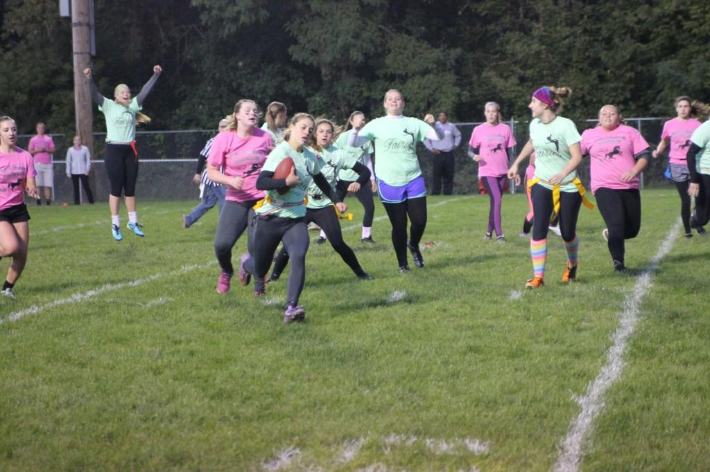 As teammates cheer her on, Senior Taylor Sherman runs the ball during the powderpuff game Oct. 1.
