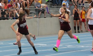 Faith Anton hands off the baton to Maggie Davis at state in May. Photo by Kelbie Eskelsen.