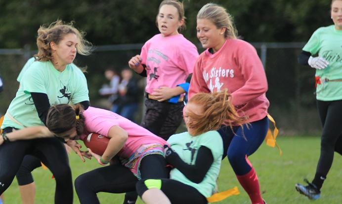 Junior Haley Corkin is stopped by sophomore Laurel Sherman and Senior Audrey Lester in the powderpuff game Oct. 1. Photo by Abdur Rafay. 