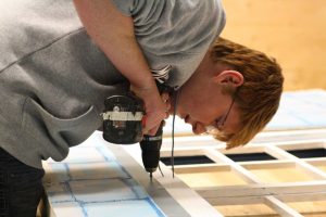 Concentrating on his task at hand, Sayre Pollock, puts a window together. The tech crew spent four hours on Sunday, October 25, building doors and windows.