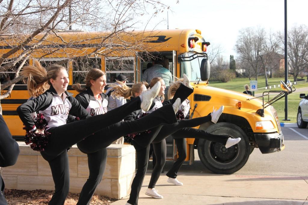 Cheerleaders dance to the fight song played by the pep band as the players load onto the bus Nov. 14.