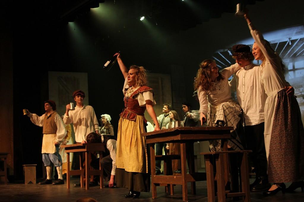 Raising a glass to all their accomplishments, the cast of Les Miserables celebrates during a dress rehearsal. Photo by Breanna Jones