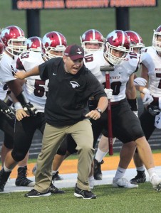 Coach Haddy holds the team back before they storm the field before the game at Solon on Aug 26. Senior Jack Cochrane leads with the sledgehammer in hand. 