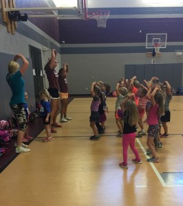 Senior cheerleaders Si'le Pollock, Jenna Baumler, and Sidney Hampton lead the Mini Mustangs in the Cookie Monster cheer on Sept. 15.