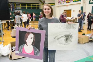 Kate Margheim holds her art entries.