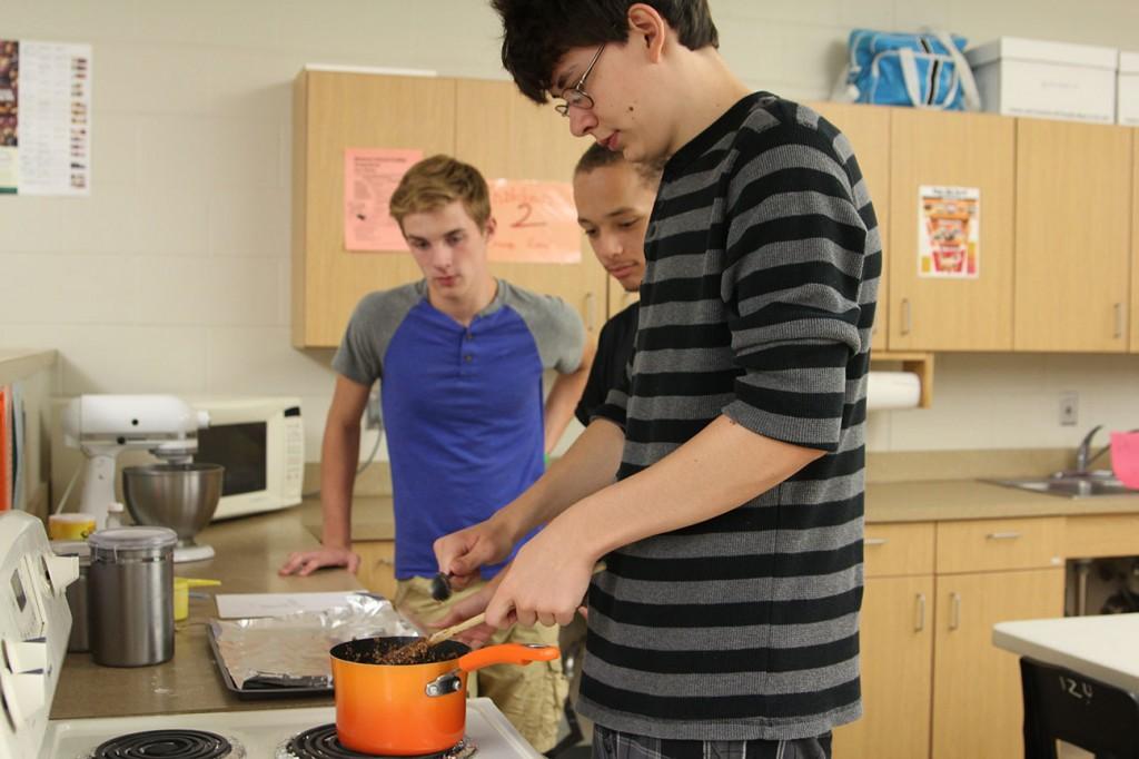 Martin Benesh mixes up no bake cookies with Reese Panos, and Noah White. Photo by Lauren McCollum. 