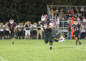Hunter Hormann runs the football after catching an interception late in the fourth quarter. Photo by Paige Zaruba. 