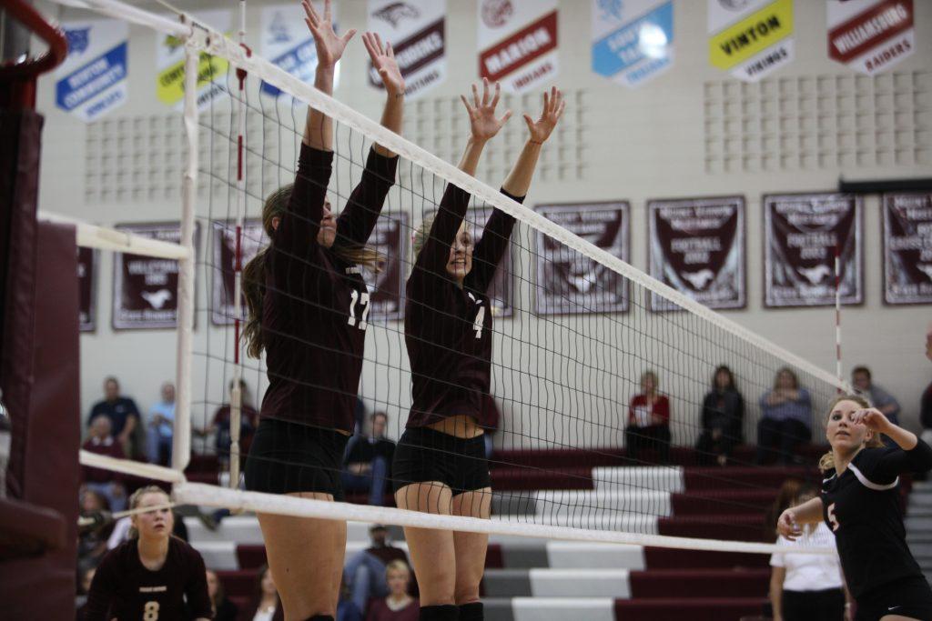 Kaitlyn Volesky and Rory Light work to block the ball at the front of the net during the volleyball playoff game. 