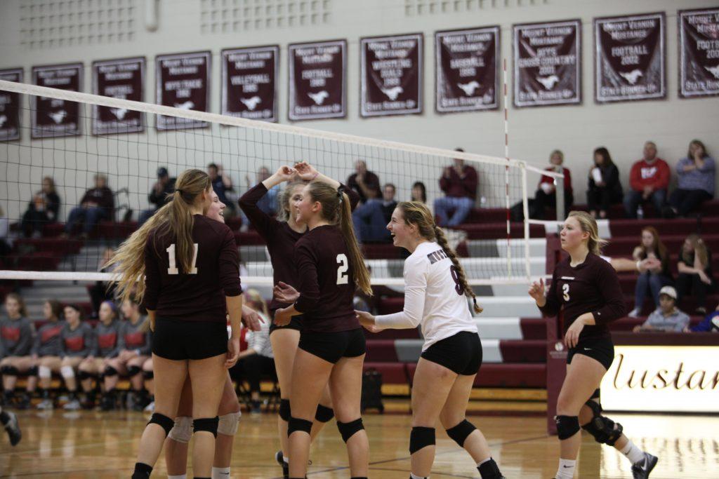 The volleyball team celebrates after scoring against Williamsburg.