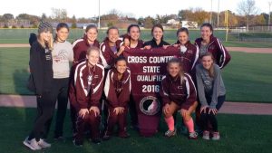 Girls XC team holds the banner after the qualifying meet at Solon on Oct. 20.