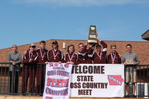 The MVLXC team raises the championship trophy: Coach Sue Deibner, David Wolfe, Garrett Herring, Zach Krogmann, Liam Conroy, Jack Young, Chase McLaughlin, Thatcher Krob, Coach Kory Swart. Photo By Ben McGuire 