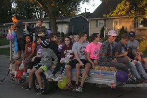 The cross country team rides a float in the homecoming parade Sept. 30. Photo by Lexi Flockhart.