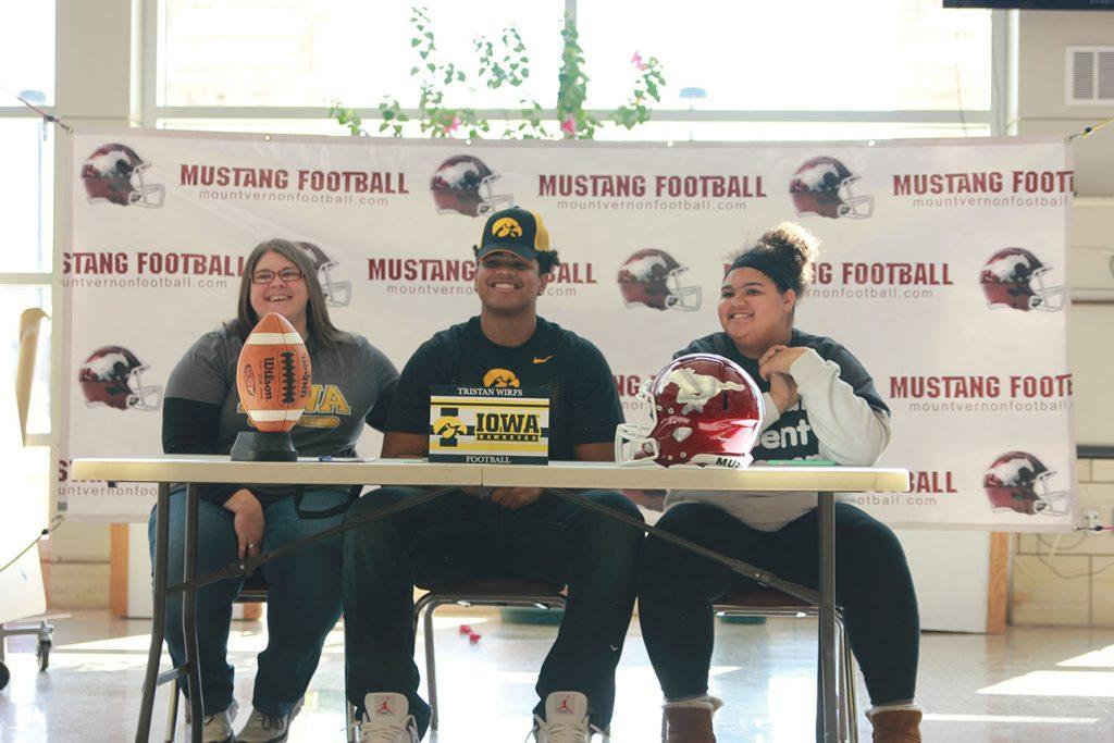 Senior Tristan Wirfs makes his commitment to University of Iowa football official Feb. 1. Wirfs had the support of his mother and sister pictured with him. Photo by Ben McGuire.