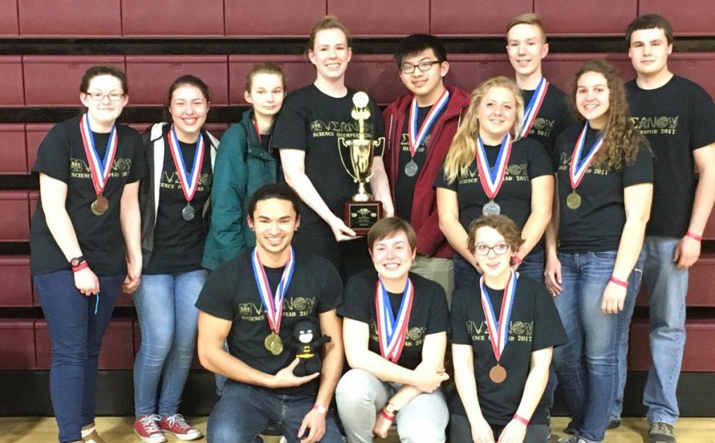 SCIENCE OLYMPIAD STATE CHAMPS: Front Row: Journey Dawa, Emily Tvedt, and Heather Boothman. Back Row: Sadie Player, Lily Cripe, Lexi Flockhart, Coach Alaina Appley, Alex Huang, Kate Liberko, Evan Tvedt, Laurel Sherman, and Brandon Lochner.