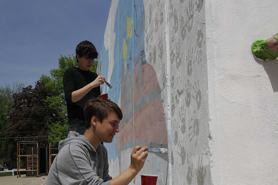 Martin Benesh and Haley Krob paint the wall on May 9. Photo by Brian Harris.