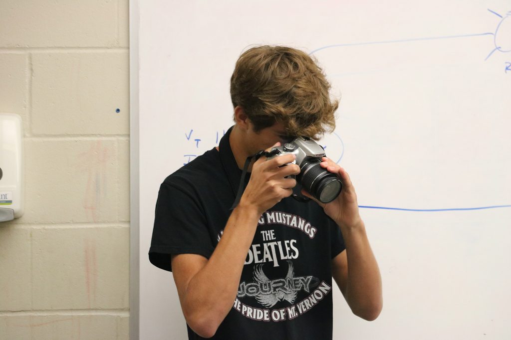 Junior Oliver Crocker takes photos of the electricity class on Aug. 31. Photo by Maddie Naeve.