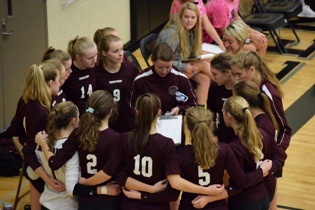 The team huddles with Coach Maggie Willems Sept. 15 in Red Oak. Photo by Mike Cranston.