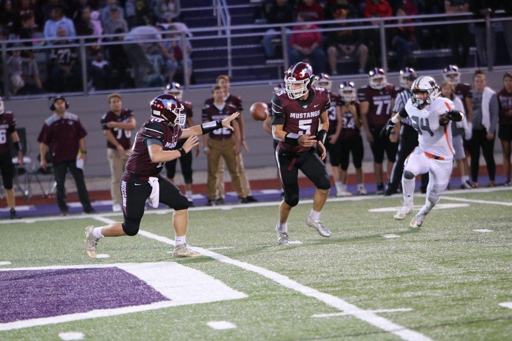 Sophomore Brady Ketchum pitches the ball to senior running back Paul Ryan. Photo by Caroline Voss.