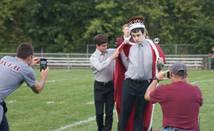 Mount Vernon alumni Ryan Clark hands the kings cape over to LaFollette.