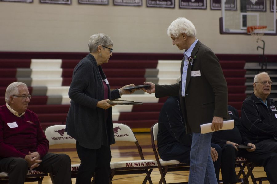 Seeing great accomplishments in Bob Bowman '58, Marilyn Schnittjer, who nominated Bowman, hands him his Athletic Hall of Fame Award. Bowman was the quarterback his senior year for the football team and is honored to be the recipient of this award. 