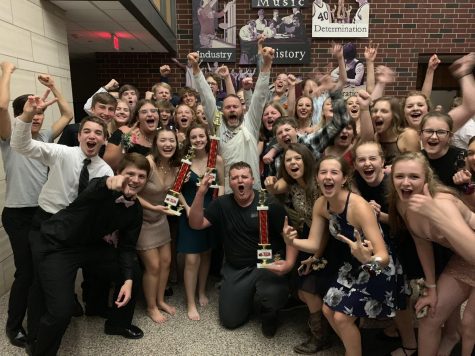 Marching Mustangs and director Scott Weber pose with trophies at the Homecoming dance.