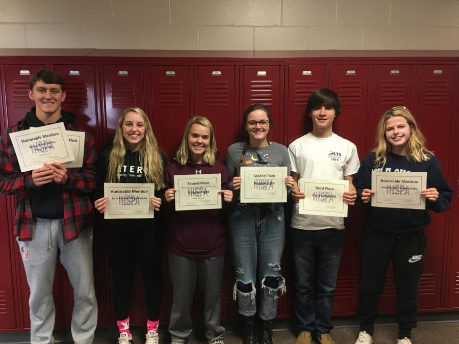 Student journalists hold their awards received for their contributions to the yearbook Oct. 31. The students pictured are (left to right) Aydan Holub-Schultz, Jorie Randall, Reagan Light, Lillie Hawker, Kai Yamanishi, and Lauren McCollum. Not pictured: Caroline Voss. Photo by JoAnn Gage