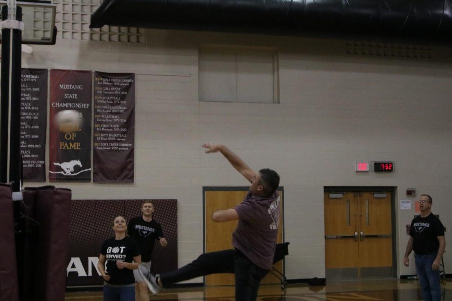 Principal Steve Brand spikes the ball over the net while playing against his sons.