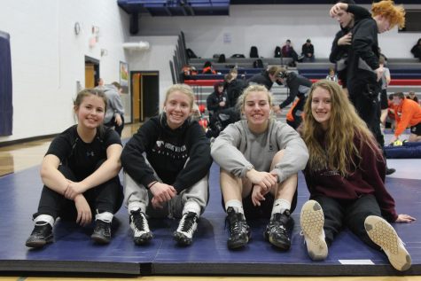 Wrestlers Abbie Morf, Julia Wheeler, Maddie Shultz, and Maddy Plotz pose at a tournament. Absent from photo are wrestlers Reagan Light and Tori Oelrich