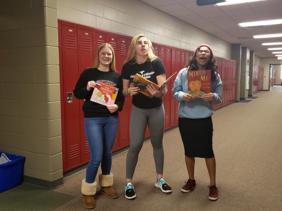 Maddie Shultz, Saqua Werling, and Hadley Anderson pose with childrens books they read  in Social Justice Jan. 10.