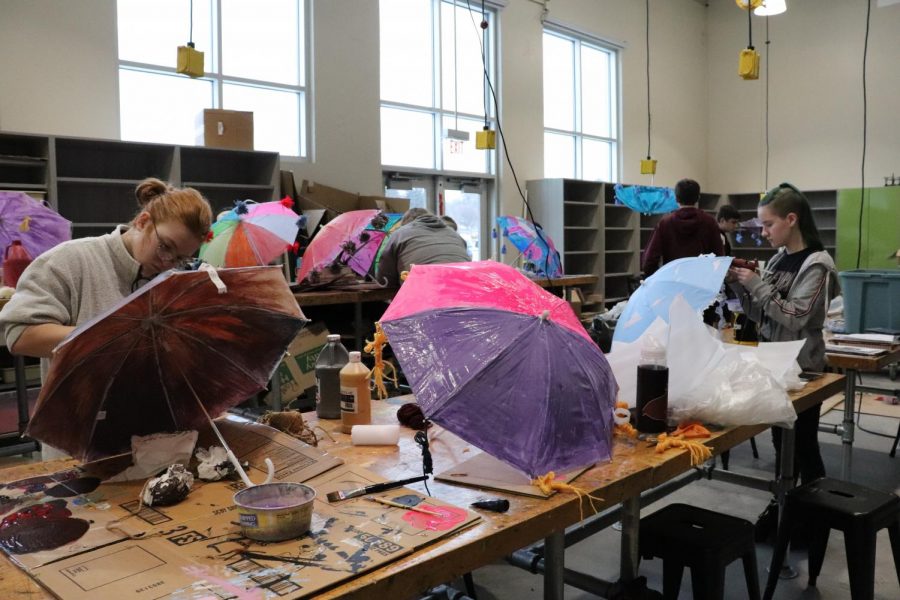 Festivals, Parades, and Giant Puppets paint umbrellas in the new art room.