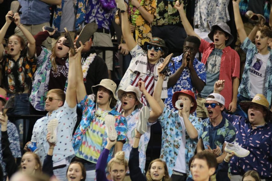 Fans cheer in the student section at state finals in their tourist theme attire.