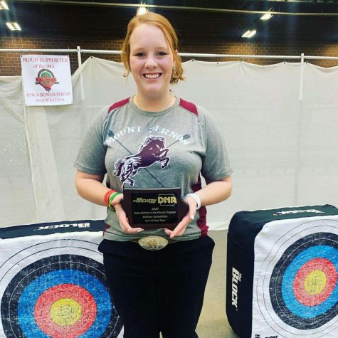 Senior Paige Emig smiles as she holds her award for placing fifth at state archery with a score of 290.