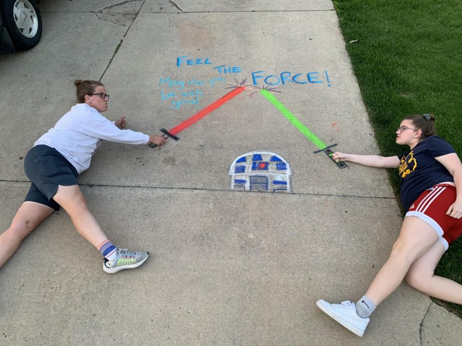Crystal Eskelsen and daugther Macy, a freshman, pose with their chalk art. The Eskelsens started the Facebook group Fresh Air Heads to inspire the community to get outside safely during social distancing. 