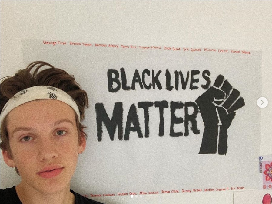 Dallas Olberding poses with his artwork in response to the killing of George Floyd May 25 and the protests of continued racial injustice.