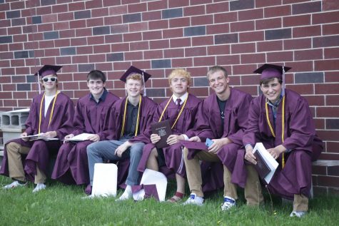 Luke Wade, Kode Banwart, Sam Adams, Graham Bradbury, Garrett Hormann, and Jack Kragenbrink sit behind the school after receiving their diplomas May 24.