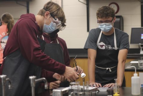 Juniors Trenton Pitlik and Brody Ulch attempt to light a bunsen burner during a chemistry lab Sept. 16. To light the burner takes a bit skill and patience when it comes to applying enough force to create sparks with the lighter. 