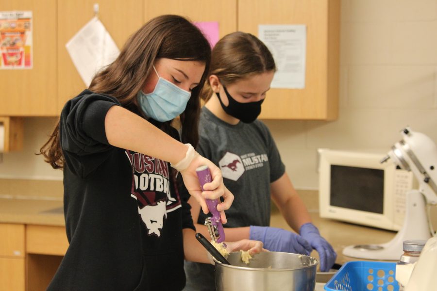 Freshman Kelsey Kamerling scoops out cookie dough in Foods Sept. 11. Kamerling and sophomore Isabel Hawker made snickerdoodle cookies for their foods lab.