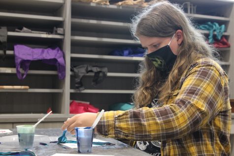 Senior Quinn Alles pours paint onto a canvas in Art Media Survey Sept. 11. Alles used three different colors in her acrylic pour painting. That project was super fun. Alles said, We got to experiment a lot with color schemes and ways to make different shades of colors.
