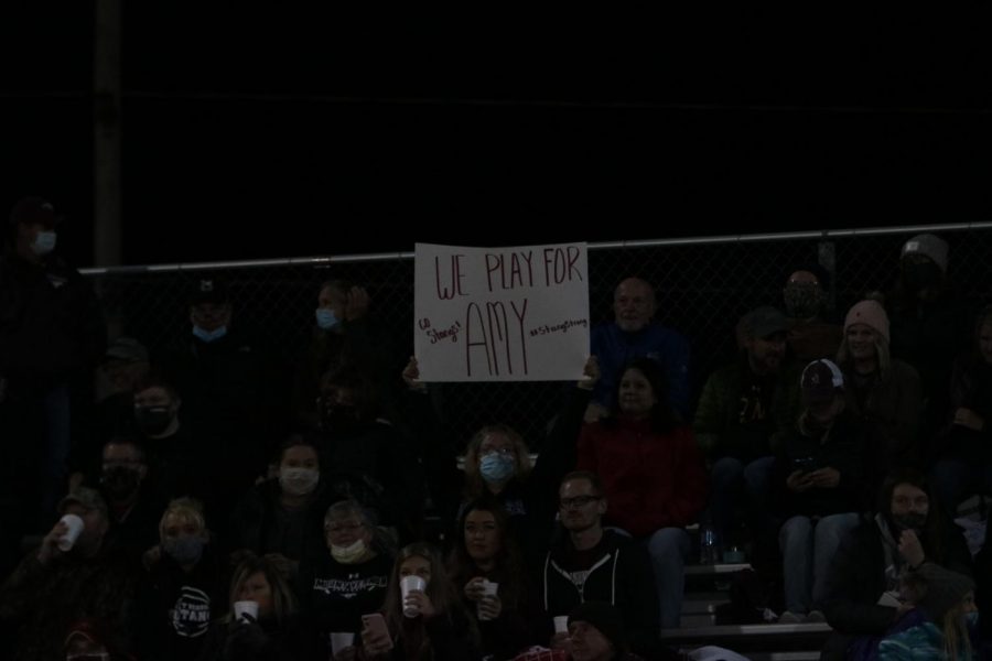 Suzzie Ketchum holds up a sign for Amy Hird, Solon Oct. 2. The Mustangs lost 42-14