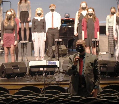 Director, Thad Wilkins, informs audience about the music concert choir sings and speaks proudly of his students. 